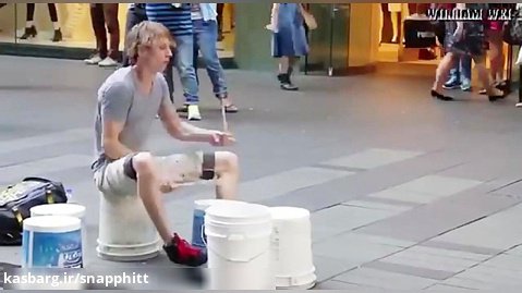 درام نوازی یک هنرمند با سطل پلاستیکی در خیابان